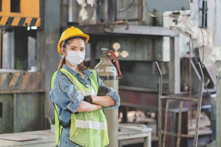 Asian female engineers wearing hygienic mask protect with helmet safety in factory. Coronavirus Protective, safety conceptの写真素材