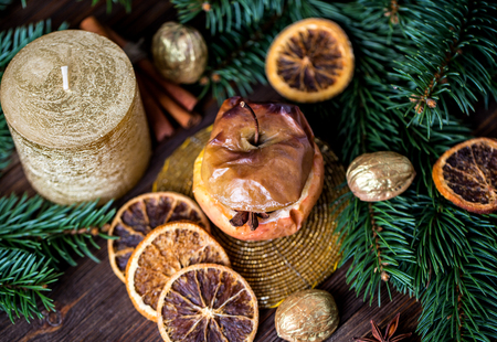 Baked apples with cinnamon on rustic background. Autumn or winter dessert. Closeup photo of a tasty baked apples with christmas decorationの写真素材