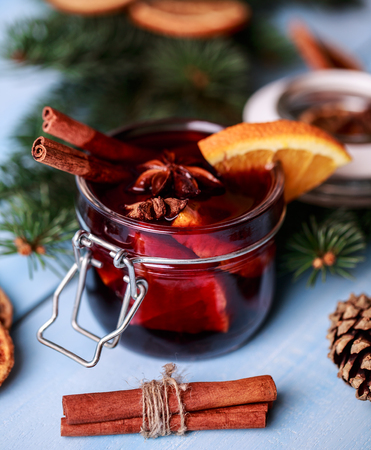 Mulled wine in a glass. Christmas hot mulled wine in a glass with spices and citrus fruit. Mulled wine with cinnamon anise and orange. Christmas atmosphereの写真素材