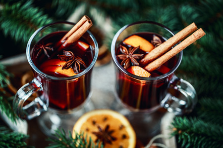 Christmas hot mulled wine in a glass with spices and citrus fruit. Mulled wine with cinnamon, anise and orangeの写真素材