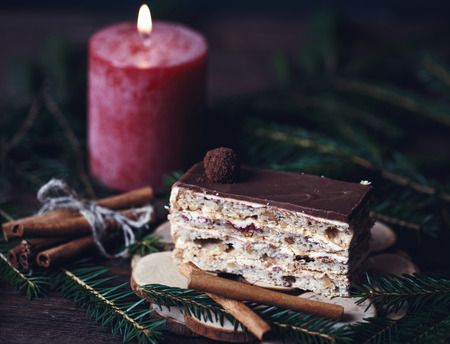 Christmas tasty cake on a dark wooden background with spruce decoration.
