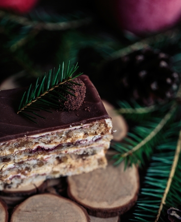 Christmas tasty cake on a dark wooden background with spruce decoration.の写真素材