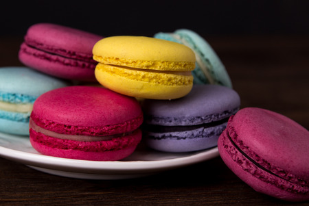 Colorful macaroons on a dark wooden background. Macaroons close upの写真素材