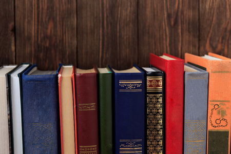 Many old books on a wooden background. The source of information. Open book indoor. Home library. Knowledge is powerの写真素材
