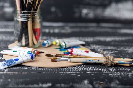 Art and craft tools.Artist's brush, canvas. Wooden art palette with tubes of acrylic paints.Artist's workshop.Art picture with copy space and for add text.Artist workplace background.Paints brushes