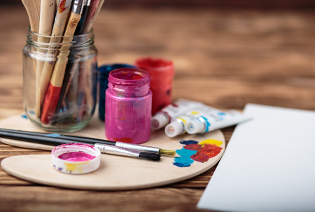 Artist's workshop. Canvas, paint, brushes, palette knife lying on the table.Art tools.Artist workplace background.Acrylic paint and brushes.Art picture with copy space and for add text.の写真素材