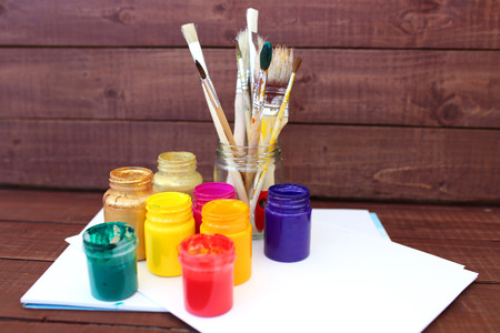 Multicolored plastic cans with paints. Artist workplace background.の写真素材