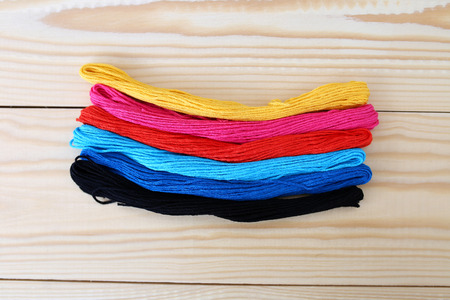 Colored threads on a wooden background. Sewing kit. Set for needlework