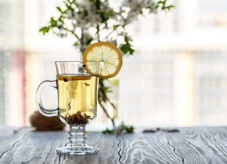 Fresh green tea. Tea cup with green tea leaf on the wooden table. Tea with lemonの写真素材