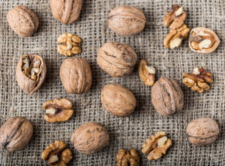 Walnuts. Walnut kernels and whole walnuts on rustic table.