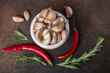 Fresh garlic with chili pepper and rosemary on wooden background. Garlic bulbsの写真素材