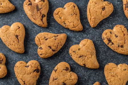 Chocolate cookies on wooden rustic table. Chocolate chip cookies in the shape of a heart. Homemade cookiesの写真素材
