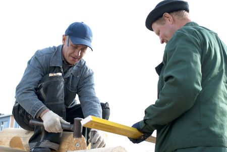 Carpenters works on the wall of log cabin