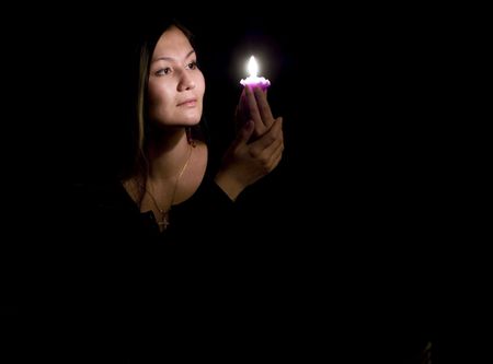 Portrait of yoing woman in darkness with candleの写真素材