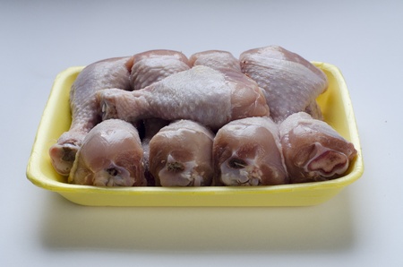 Chicken legs in yellow plastic containerの写真素材