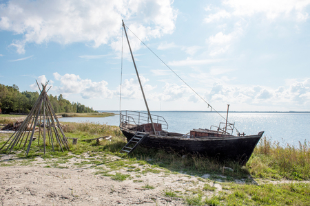 old wooden fishing boat on the shore of Baltic seaの写真素材