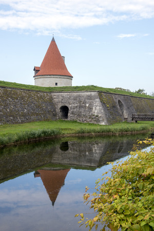 Tower and the wall of ancient fortress in Kuressaare, Estonia, reflected in the moatの写真素材