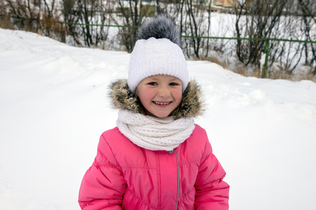 Portrait of young beautiful girl against the snowy background in winterの写真素材
