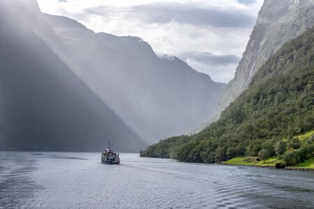 Norvay, Gudvangenfjord. The cruise ship sailing away into the misty fjordの写真素材