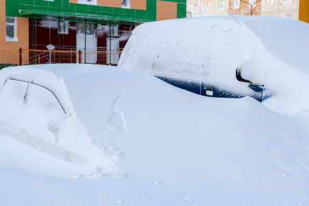 Car buried under a huge snowdrift after snowstormの写真素材