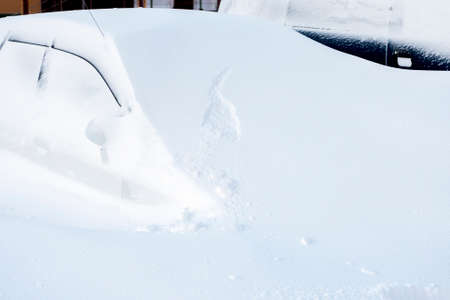 Car buried under a huge snowdrift after snowstormの写真素材