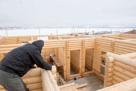 Carpenter works at the construction of wooden houseの写真素材
