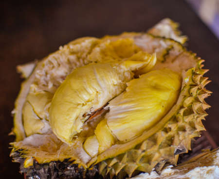 Durian ripe and fresh cut open to reveal the yellow-orange pulp. King of fruit has a sweet and unusual tasteの写真素材