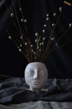 earthenware vase in the shape of a human face with willow. High quality photoの写真素材
