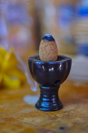 Home made incense cones on a ceramic stand with aroma smokeの写真素材