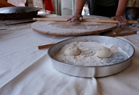 close up the process of rolling dough with a rolling pinの写真素材
