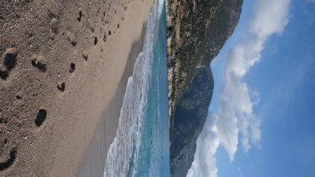 view from the beach to the sand of the mediterranean sea and mountainsの写真素材