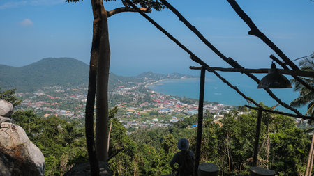 Samui island viewpoint. Person is comfortably sitting beneath a lovely canopy that offers a beautiful view of both the city skyline and the vast ocean beyond.の写真素材