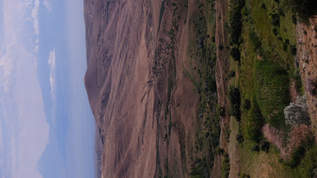 A breathtaking scene that showcases undulating hills and varying patches of greenery beneath a dramatic skyの写真素材