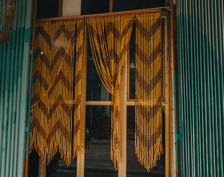 Beautiful vintage macram curtains hanging in a rustic window ambianceの写真素材