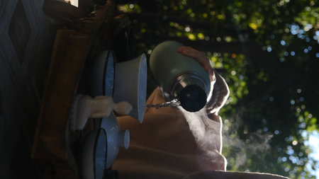 A peaceful and serene moment of tea being poured gracefully, beautifully surrounded by natures exquisite beautyの写真素材