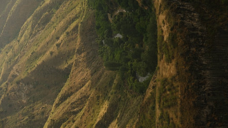 Mountain landscape near Garni Temple in Armenia with yellow-green grasses, slopes and soft sunset...