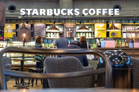 Lyon, France - 16 March 2019: People ordering coffee and cookies at Starbucks inside Lyon Saint Exupery International airport, while waiting in-between flights. Airport coffee and relax - editorial.のeditorial素材