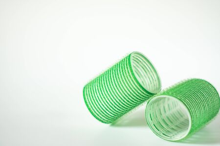 Close-up of two green hair curlers on a white background.の写真素材