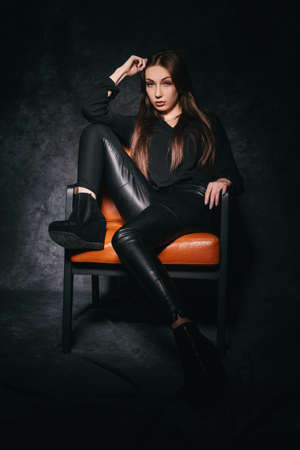 Beautiful brunette in the studio on a dark background in a photo studioの写真素材