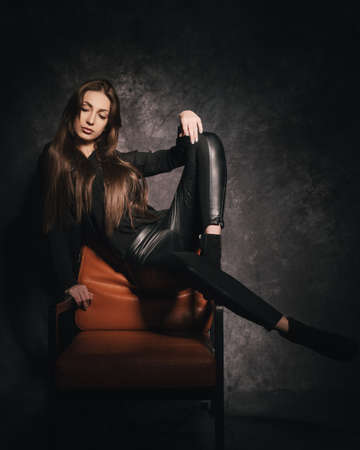 Beautiful brunette in the studio on a dark background in a photo studioの写真素材