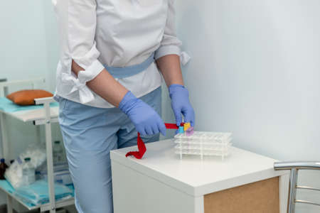 Laboratory with nurse taking a blood sample from patient, in background samples blood .