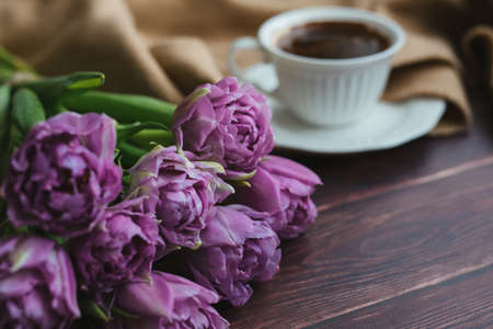 Spring flowers. Bouquet of tulips on a wooden background. Coffee and tulips. Flatley.の写真素材