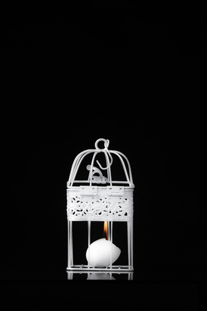 burning egg in a white cage on a black backgroundの写真素材