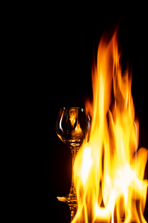 a glass and a bottle of wine on fireの写真素材