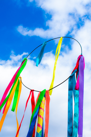 circle with colorful ribbons against the blue skyの写真素材