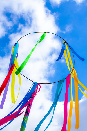 circle with colorful ribbons against the blue skyの写真素材