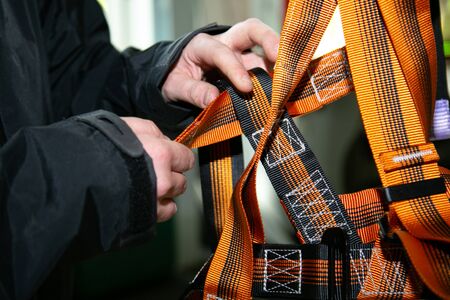 Mens hands feel safety equipment for work at heights