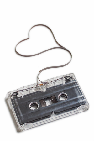 Audio cassette with magnetic tape in shape of heart on white background. I love music concept.の写真素材
