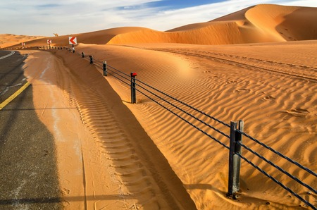 A road through the desert dunes taken in the Liwa Oasis, Abu Dhabi area, United Arab Emirates