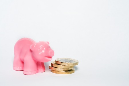 Close Up View of British Pound Coins and Pink Pigの写真素材